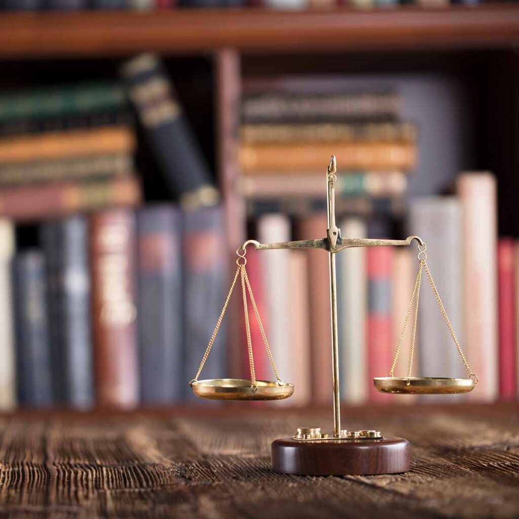 Scales of Justice on desk with books in background