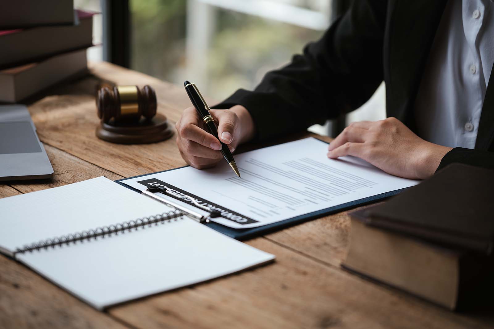 Business person at desk writing with pen