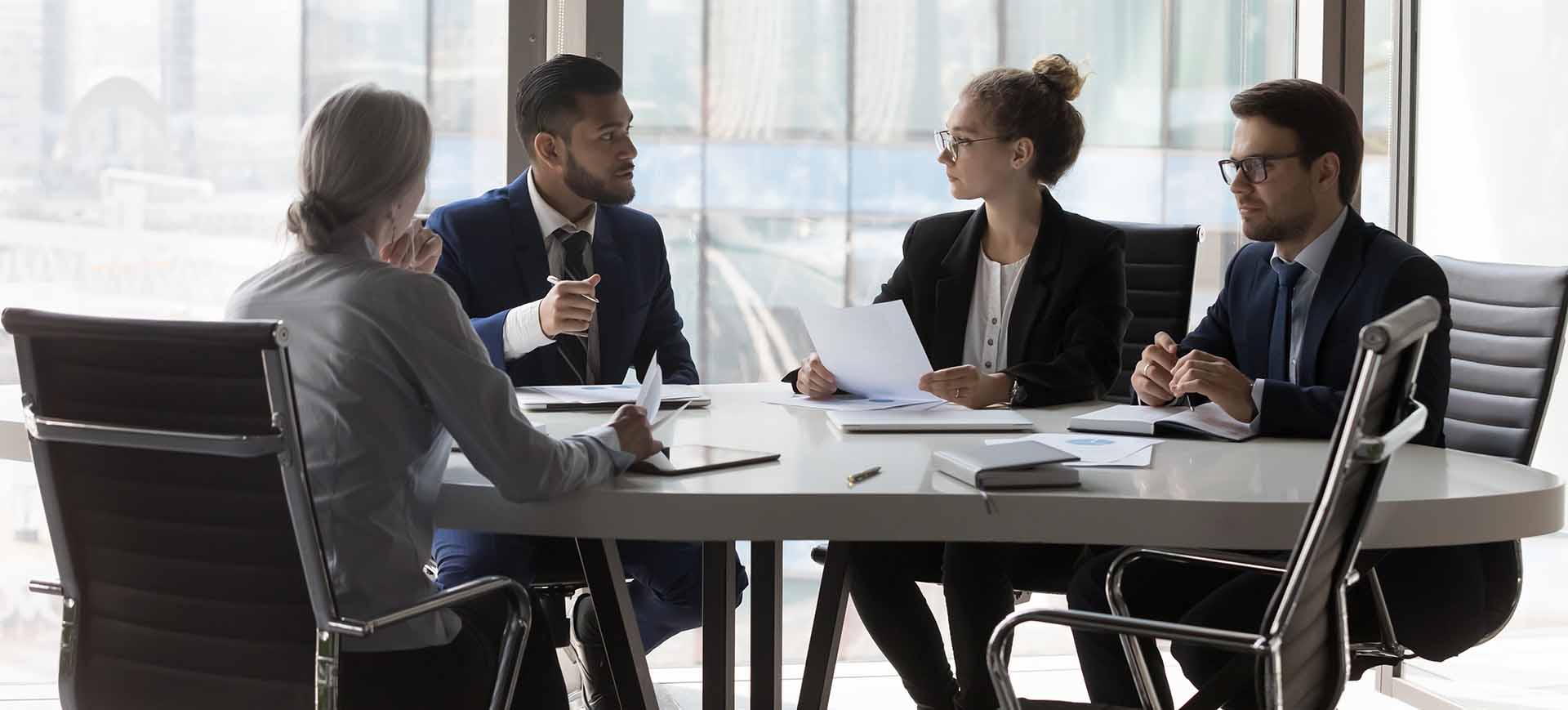 4 business professionals in meeting at conference table